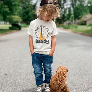 a little boy standing next to a brown dog