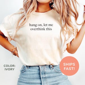 a woman wearing a t - shirt that says hang on, let me overthi