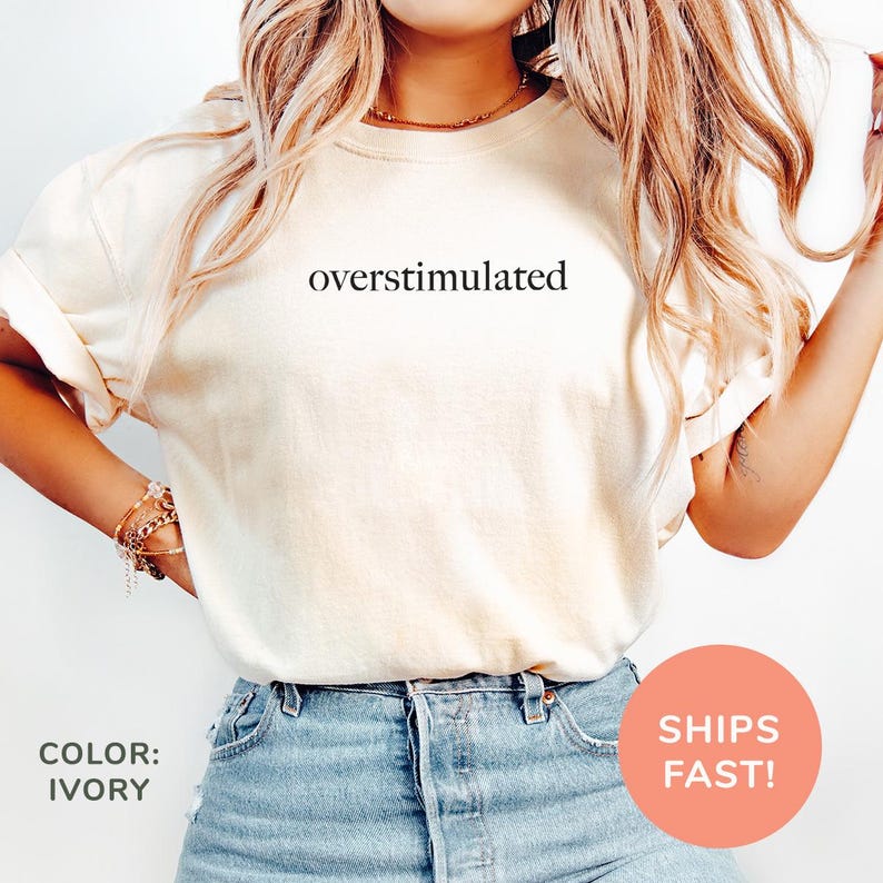 a woman wearing a white shirt with the words oversimulated on it