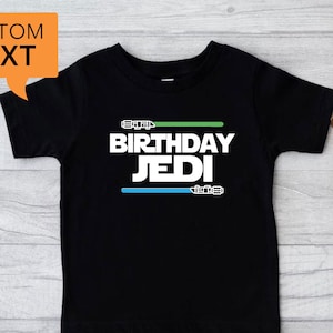 May include: Black t-shirt with a white graphic that says "Birthday Jedi" with green and blue lightsaber designs.