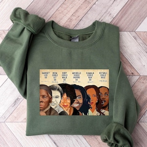 May include: Green sweatshirt with a graphic print of six women, including Harriet Tubman, Rosa Parks, Ruby Bridges, Michelle Obama, Kamala Harris, and Ketanji Brown Jackson. The text on the graphic reads "Harriet Led 30, Rosa Could Sit 30, Ruby Could Walk 30, Michelle Could Inspire 30, Kamala Could Run 30, Ketanji Could Rule 30."