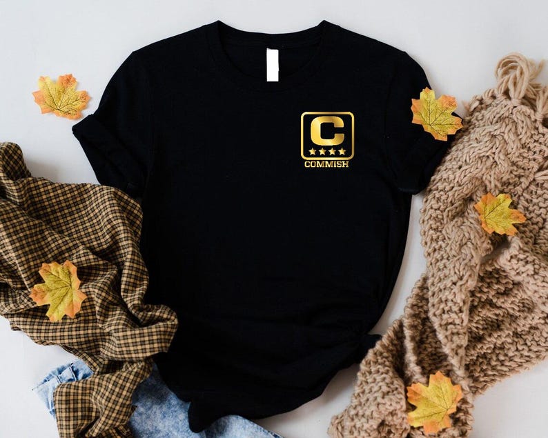 a black t - shirt with yellow and brown leaves on it