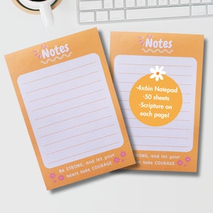 May include: Two orange notepads with lined pages. The top of each notepad reads "Notes" in a playful font. One notepad has a circular sticker with text: "-4x6in Notepad -50 sheets -Scripture on each page!" The bottom reads "Be STRONG, and let your heart take COURAGE."