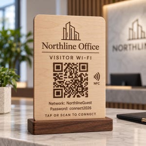 以下が含まれることがあります： ダークウッドのベースが付いた長方形のライトウッドサイン。Northline Officeのロゴ、QRコード、NFCアイコン、およびVisitor Wi-Fi、Network: NorthlineGuest、Password: connect2026、Tap or Scan to Connectというテキストが暗いインクで印刷されています。