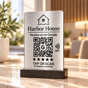 May include: A rectangular brushed silver sign with a dark wood base featuring a house icon, the text Harbor House, Review us on Google, a QR code with a central G logo, an NFC symbol, five black stars, and the text TAP OR SCAN to leave a review.