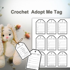 May include: A cream crochet bunny with long ears and a pink nose, alongside "Adopt Me" tags. The tags feature fill-in sections for name, personality, favourite food, colour, and hobbies. Small crochet carrots are also present in the image.