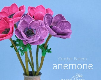 May include: Crochet pattern for an anemone flower. The pattern is called "anemone" and is by Happy Patty Crochet. The image shows a bouquet of crocheted anemones in shades of pink and purple.