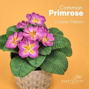 Może przedstawiać: Szydełkowa roślina pierwiosnka w ozdobnej doniczce. Kwiaty są różowe z żółtymi środkami, a liście zielone. Tekst brzmi "Common Primrose Crochet Pattern".