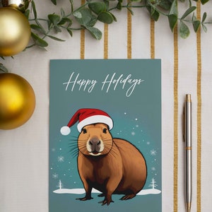 Leuke wintercapibara-briefkaart | Unieke, met de hand geïllustreerde kerstwenskaart voor seizoensgejuich | Kerstcapibara ansichtkaart cadeau