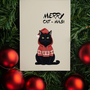 Carte de Noël de chat mignon. Chat avec pull de Noël. Jeu de cartes de vœux drôles de chat noir.
