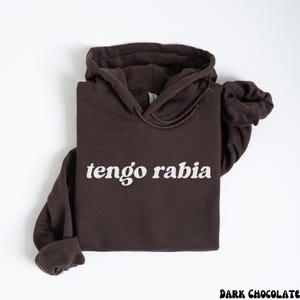 May include: A dark brown hoodie with the text "tengo rabia" in white lettering.