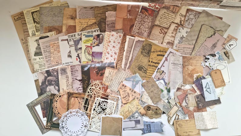 Op de afbeelding: Een verzameling papieren ephemera in vintage-stijl, waaronder verouderde papieren vellen, ansichtkaarten, labels en decoratieve elementen. De papieren hebben vervaagde kleuren, antieke lettertypen en illustraties, wat een nostalgische uitstraling cre&euml;ert.