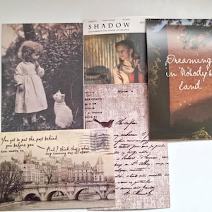 Op de afbeelding: Een verzameling ansichtkaarten in vintage-stijl en een tijdschrift. De ansichtkaarten tonen sepia-kleurige afbeeldingen van een kind met een kat, een brug en handgeschreven tekst. De omslag van het tijdschrift luidt "SHADOW" en "Dreaming in Nobody's Land".