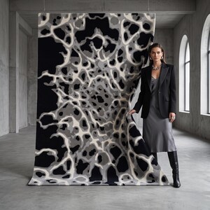Puede incluir: Una alfombra rectangular grande con un patr&oacute;n org&aacute;nico abstracto en tonos negro, blanco y gris. El dise&ntilde;o consiste en formas fluidas interconectadas que se asemejan a un mapa celular o topogr&aacute;fico, exhibido en una orientaci&oacute;n vertical.
