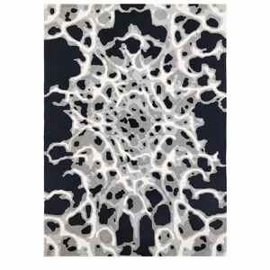 Puede incluir: Una alfombra rectangular con un patr&oacute;n abstracto de alto contraste en negro, blanco y varios tonos de gris. El dise&ntilde;o consiste en formas org&aacute;nicas interconectadas que irradian desde el centro, creando un efecto visual complejo y estratificado.