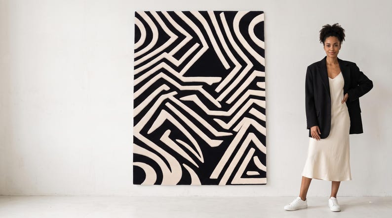 Puede incluir: Una gran pieza de arte mural rectangular con un patr&oacute;n gr&aacute;fico de alto contraste de l&iacute;neas gruesas entrelazadas en negro y crema. El dise&ntilde;o consiste en formas geom&eacute;tricas y caminos curvos que crean un efecto visual complejo y laber&iacute;ntico.