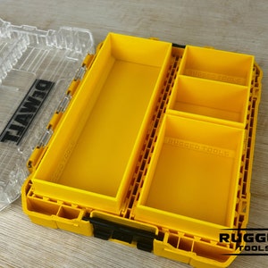 May include: A yellow plastic tool box with a clear lid. The box has a removable tray with multiple compartments. The tray is labeled "Rugged Tools".