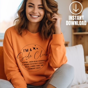 May include: Orange sweatshirt with a black circle graphic that says "I'm a Side Chick" with a list of Thanksgiving side dishes.