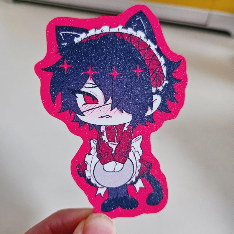 May include: A pink sticker featuring an anime-style character in a maid outfit with cat ears. The character has dark blue hair, red eyes, and a blush. The sticker has a glittery finish.