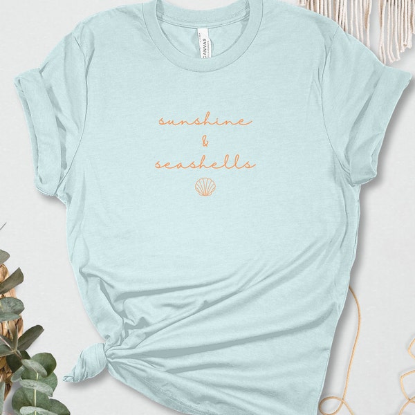 Pretty, minimalist sunshine and sea shells shirt. This beach lovers T-shirt has a simple cursive script with a single scallop shell below