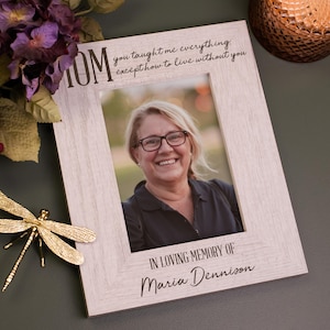 May include: A white wooden picture frame with a black inscription that reads "You taught me everything except how to live without you."  The inscription is in a handwritten font.  The frame has a photo of a woman smiling.  The inscription below the photo reads "In loving memory of Maria Dennison."