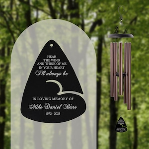 May include: A black wind chime with a memorial plaque that reads "Hear the wind and think of me in your heart I'll always be" and "In loving memory of Mike Daniel Bure 1972-2023".