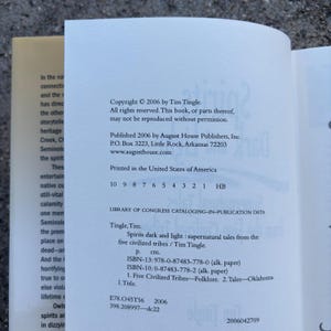 May include: A book with a white cover and text, titled "Spirits dark and light: supernatural tales from the five civilized tribes". Published in 2006 by August House Publishers, Inc. The book's ISBN is 978-0-87483-778-0.