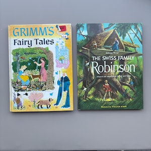 May include: Two vintage hardcover books. Grimm's Fairy Tales features a yellow cover with a colorful illustration of a forest scene, a castle, and a king. The Swiss Family Robinson features a green cover with an illustration of a treehouse.
