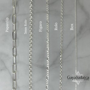Può includere: Cinque tipi diversi di catene d'argento: catena a maglie, catena rolo da 5 mm, catena figaro, catena rolo e catena a scatola. Le catene sono mostrate su uno sfondo di marmo bianco.