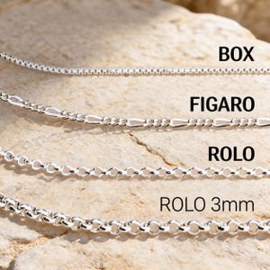Labeled sterling silver chains on travertine stone: box, figaro, rolo and 3mm rolo chains to compare link size and style