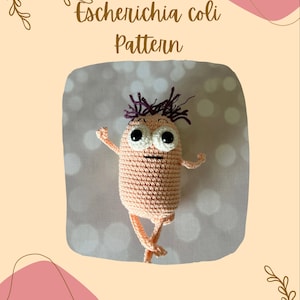 Peut inclure: Un jouet amigurumi en crochet en forme de bactérie avec une touffe de cheveux violette, de grands yeux blancs et un corps rose. Le jouet est sur un fond blanc avec le texte "Escherichia coli Pattern" au-dessus.