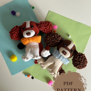 Puede incluir: Dos juguetes de amigurumi de perro tejidos a crochet con pelaje marrón y blanco, narices marrones y ojos negros. Los perros llevan pajaritas de colores y están sentados sobre un fondo verde y azul. El texto "PDF PATTERN" está escrito en un círculo marrón en la esquina inferior derecha de la imagen.