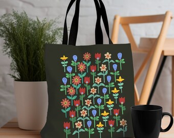 May include: A black tote bag with a floral pattern. The bag has black handles and a dark green background with colorful flowers in red, blue, yellow, and white.