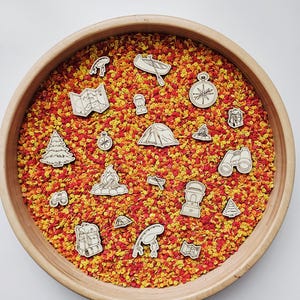 May include: A wooden bowl filled with red, orange, and yellow floral elements, with wooden camping-themed cutouts. The cutouts include a tent, compass, map, backpack, binoculars, and a canoe. The bowl has a natural wood finish.
