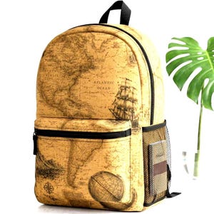 May include: A beige backpack featuring a vintage-style world map print with illustrations of a sailing ship, a globe, and mountain ranges. The bag includes a front zippered pocket, black zippers, a top handle, and a black mesh side pocket.