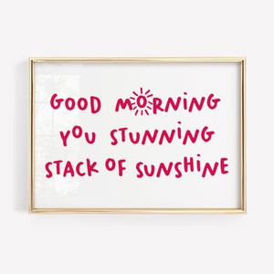 Puede incluir: Impresión enmarcada en oro con fondo blanco y texto rojo que dice "Good Morning You Stunning Stack of Sunshine".