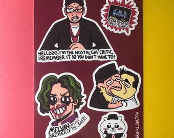 May include: A sticker sheet featuring cartoon illustrations of characters and text. The Nostalgia Critic is depicted with text that reads, "Hellooo, I'm the Nostalgia Critic, I remember it so you don't have to!" Other stickers include a Joker-like character and a Batman credit card.
