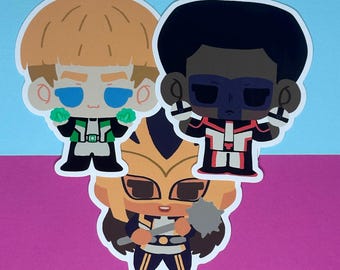 May include: Three cartoon stickers featuring characters with distinct designs. One has blonde hair and a green and black outfit, another has black hair and a red and white outfit, and the third has a yellow and black outfit.