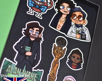 May include: A sheet of colorful stickers featuring cartoon illustrations of characters. The stickers include a character with a blue bow tie, two characters in a dark jacket, and a character holding a book with the text "ALAN" on it.