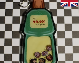 May include: Green plastic keychain shaped like a bottle of disinfectant with the text "Kills 99.9% of all germs". The bottle has a clear window showing cartoon faces inside.