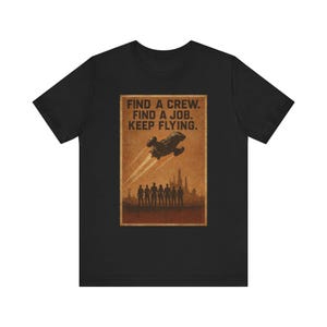 May include: Black t-shirt featuring a vintage-style poster design. The poster has a brown background with a spaceship, figures, and the text "FIND A CREW. FIND A JOB. KEEP FLYING."