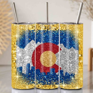May include: Three gold glitter tumblers featuring a design of the Colorado state flag. The flag depicts a red, yellow and white circle with a 'C' at its centre, surrounded by blue and white mountains against a gold glitter backdrop.
