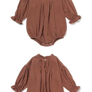 May include: A brown baby onesie with long sleeves and a ruffled neckline. The onesie has a gathered skirt and is made of a soft, comfortable fabric.