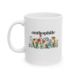 May include: White ceramic mug with a black and white graphic of flowers and the word "anthophile" printed on the front.