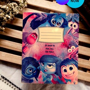 Puede incluir: Un cuaderno con personajes de la película de animación Del revés. La portada tiene un diseño colorido con el texto "IT'S OKAY TO FEEL ALL THE FEELS". El cuaderno tiene una etiqueta en blanco para un nombre.