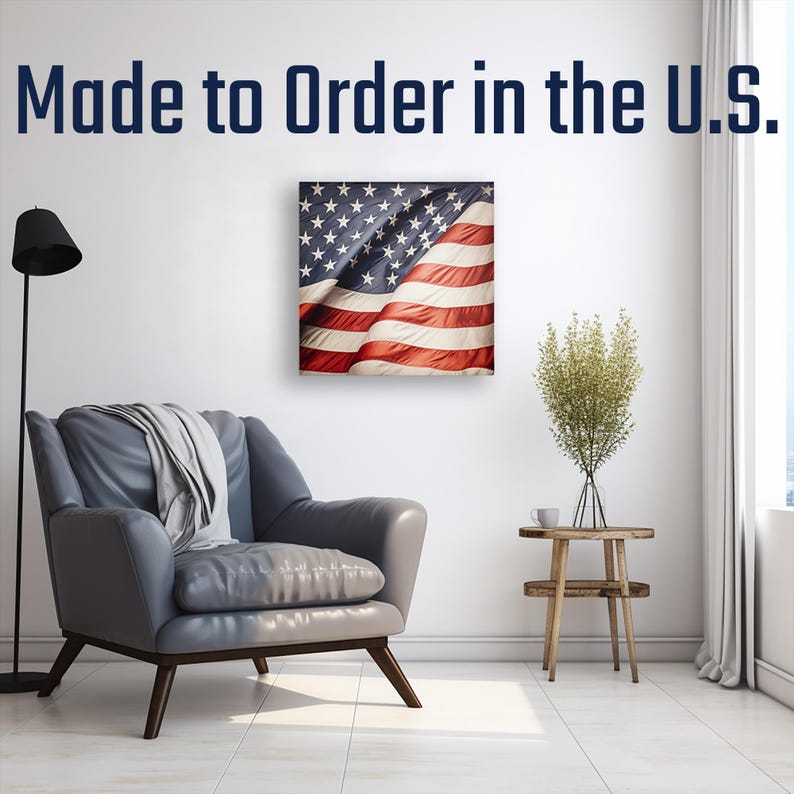 a living room with a gray armchair, a wooden side table, and a framed American flag hanging on the wall.