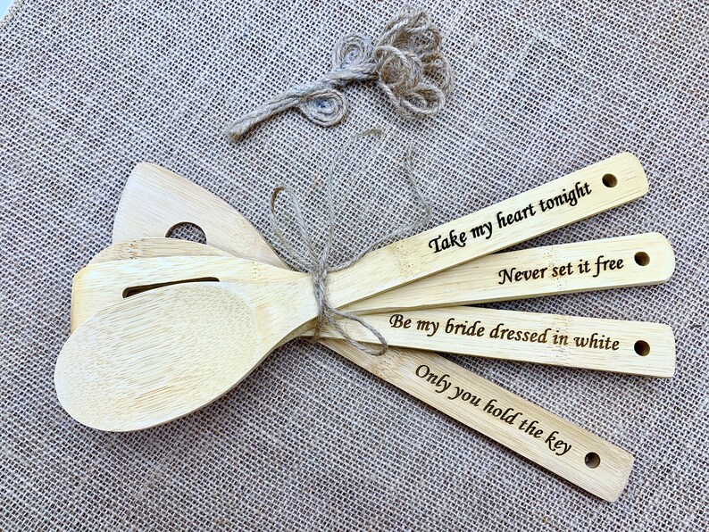 four wooden spoons with engraved words on them