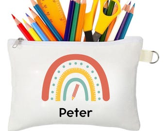 May include: White canvas pencil case with a rainbow design and the name "Peter" printed on the front. The rainbow is made up of red, orange, yellow, green, and blue stripes with white polka dots. A pencil is drawn inside the rainbow.