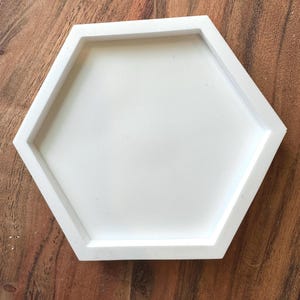 May include: A white hexagonal silicone mold for making resin crafts.
