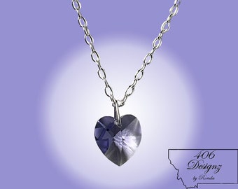 May include: A silver chain necklace with a purple heart-shaped crystal pendant.